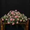Pink carnations arranged in a wicker basket with baby's breath