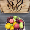 Basket of assorted fruit with grapes, apples, pears, and oranges