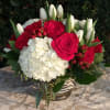 Bouquet of red roses, white tulips, and white hydrangea in a glass vase