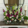 Tall floral arrangement with pink roses and magenta snapdragons in a low container