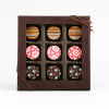 Box of assorted chocolates with patterned tops in a brown gift box