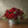 Red and burgundy flower arrangement in a ribbed metal container