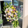 Large standing floral spray with roses, lilies, and daisies