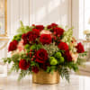 Red roses and mixed flowers arranged in a gold vase