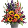 Colorful bouquet with sunflowers, roses, and mixed blooms in a gray vase