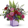 Purple and pink floral arrangement in a lavender glass vase