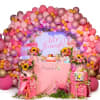 Pink balloon arch around floral party display with flamingo decor