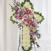 Standing floral cross with pink roses and lilies on a white easel