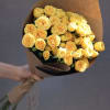 Bouquet of yellow roses wrapped in brown paper