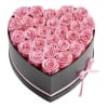 Heart-shaped box filled with pink roses and tied with a pink ribbon
