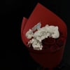 Bouquet of red roses and white orchids wrapped in red paper