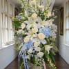 Large white and blue floral standing spray with lilies and roses