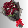 Bouquet of deep red roses wrapped in dark paper with a red ribbon
