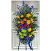 Tall standing floral spray with blue, yellow, red, and green flowers