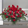 Red floral casket spray with ribbon and greenery