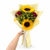 Bouquet of sunflowers and red roses wrapped in pale yellow paper