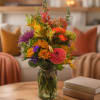Colorful mixed bouquet in a glass jar vase on a table