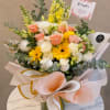 Bouquet of peach and white roses with yellow flowers in a glass vase