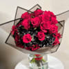 Bouquet of hot pink roses with dark filler flowers in a clear vase
