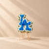 Blue and white floral standing tribute on a wooden easel