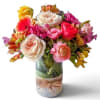 Mixed bouquet of colorful roses and gerbera daisies in a glass vase