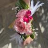 A small arrangement of beautiful flowers and greens secured to a snap