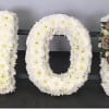 Floral letters spelling MOM in white and pink flowers