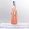 Bottle of TÖST rosé sparkling beverage on a white pedestal