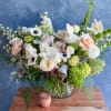 Mixed bouquet of white and blush flowers in a glass vase