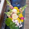 Bouquet of yellow and white flowers with pink accents in a vase