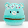 Turquoise plush bear with a smiling face and heart decorations