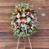 Large standing floral spray of multicolored roses and white blooms on an easel