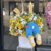 Yellow and white flower arrangement with a plush bunny in a white box