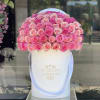 Large dome of pink roses in a white hatbox with ribbon