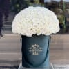 Large dome of white roses in a dark teal hatbox