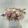 Pink and white floral arrangement in a white ribbed vase