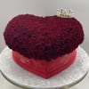 Heart-shaped box of deep red roses with a small crown topper