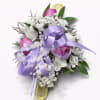Lavender and pink rosebuds cluster into a soft, romantic wrist corsage perfect