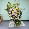 Large standing floral arrangement with lilies, roses, and daisies