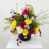 Bright mixed bouquet in a black vase with a birthday topper