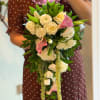 Bouquet of white roses and pink calla lilies with trailing greenery
