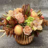 Autumn floral arrangement with peaches and roses in a ribbed glass vase