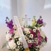 Mixed white and purple floral arrangement with a clear cross centerpiece