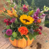 Mixed bouquet in a pumpkin-shaped container with a sunflower and orange rose