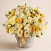 Cream and yellow rose bouquet in a gray vase with a ribbon