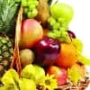 Fruit basket with apples, grapes, and yellow flowers in a wicker basket