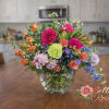Gorgeous mixed color blooms are combined with greenery to create a scene