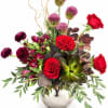 Red roses and purple blooms arranged in a silver vase