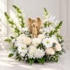 White floral arrangement with roses, daisies, and an angel figurine