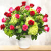 Bouquet of red and pink roses with green hydrangeas in a white vase